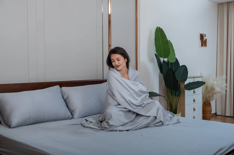 Woman sleeping on Silvery bed sheets