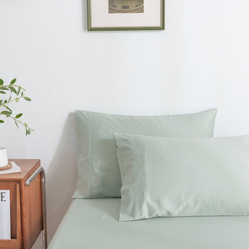Minimalist bedroom with light green dermatologist-recommended bedding designed to support clear, healthy skin.