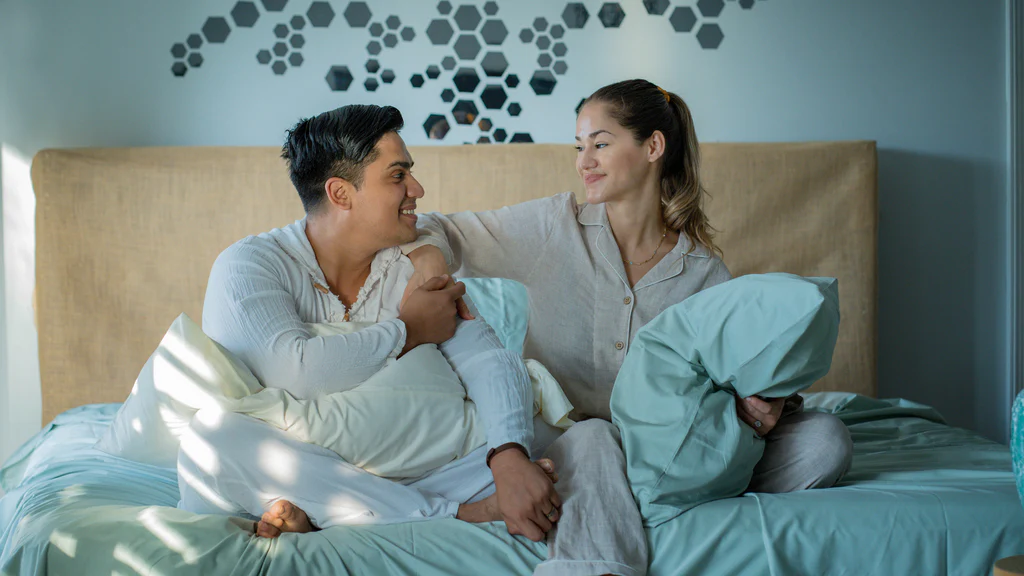 A couple enjoying a calm morning on soft mint-green organic bamboo bedsheets and pillowcases, showcasing Derme Home’s best bamboo bed sheets for sensitive skin and acne-prone users.