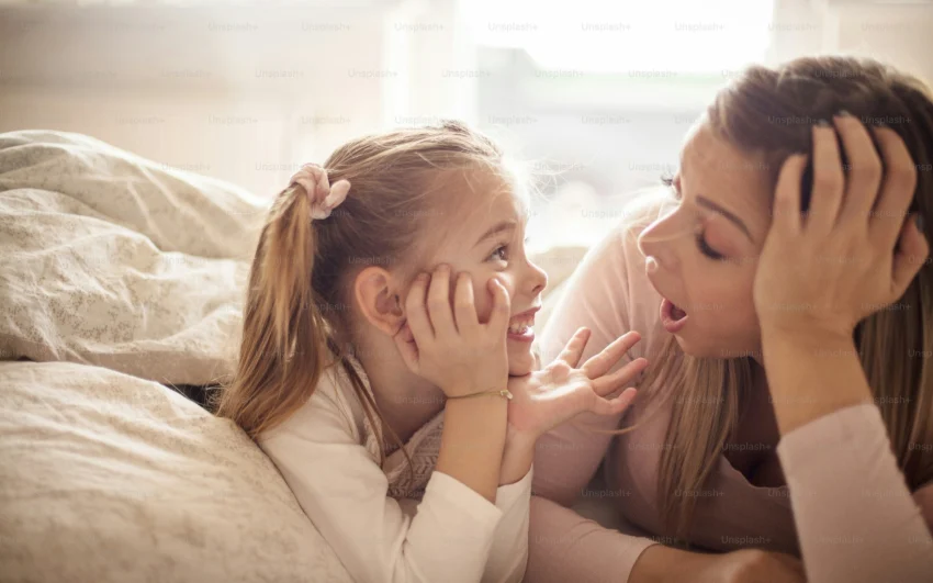 A mother and daughter smiling together on Derme Home’s organic bamboo bedsheets, highlighting premium comfort and the best bamboo bed sheets for healthy, breathable sleep.